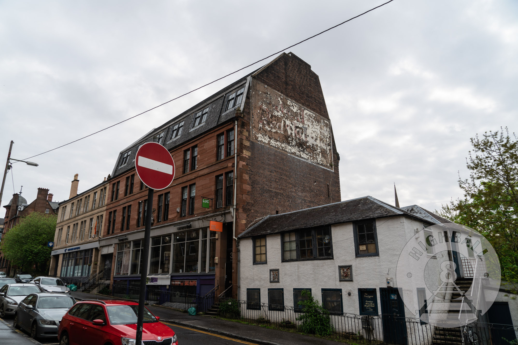 Traces of an old sign painted onto the side of a building off of the Great Western Road, Kelvinbridge, Glasgow, Scotland, UK, 2018.