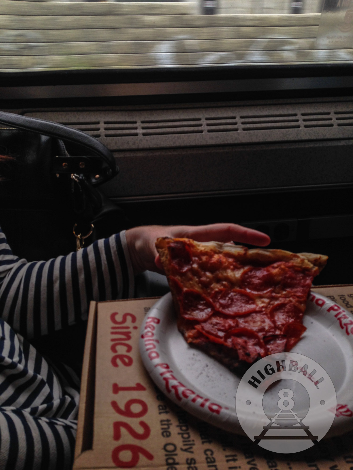 Eating pizza from Boston's Regina Pizzeria on the Portland-bound Amtrak Downeaster, Massachusetts, USA, 2014.